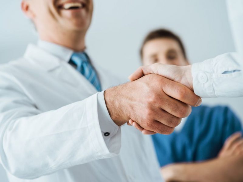 Professional doctors handshaking at hospital, hands close up, agreement and hiring concept